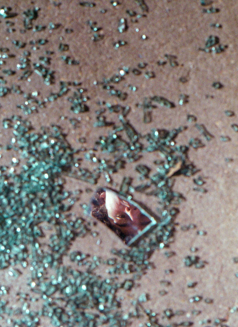 man looking at broken glass